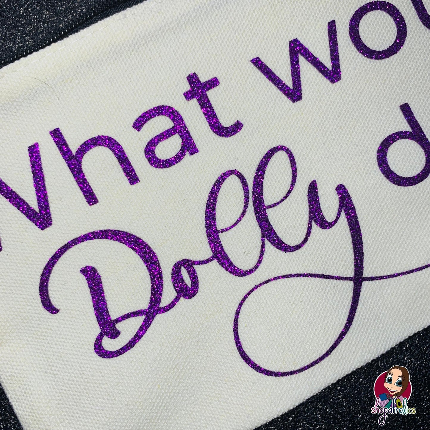 Close up of What Would Dolly Do make up bag with purple glitter lettering