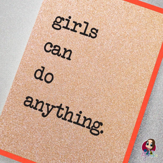 A fabulously sparkly rose gold glitter effect greeting card featuring the slogan: Girls can do anything.