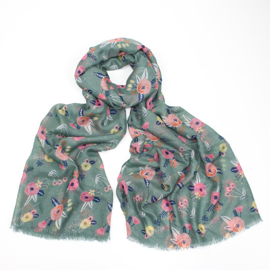 Delicate pastel pink flower printed scarf on a green background with feathered edge