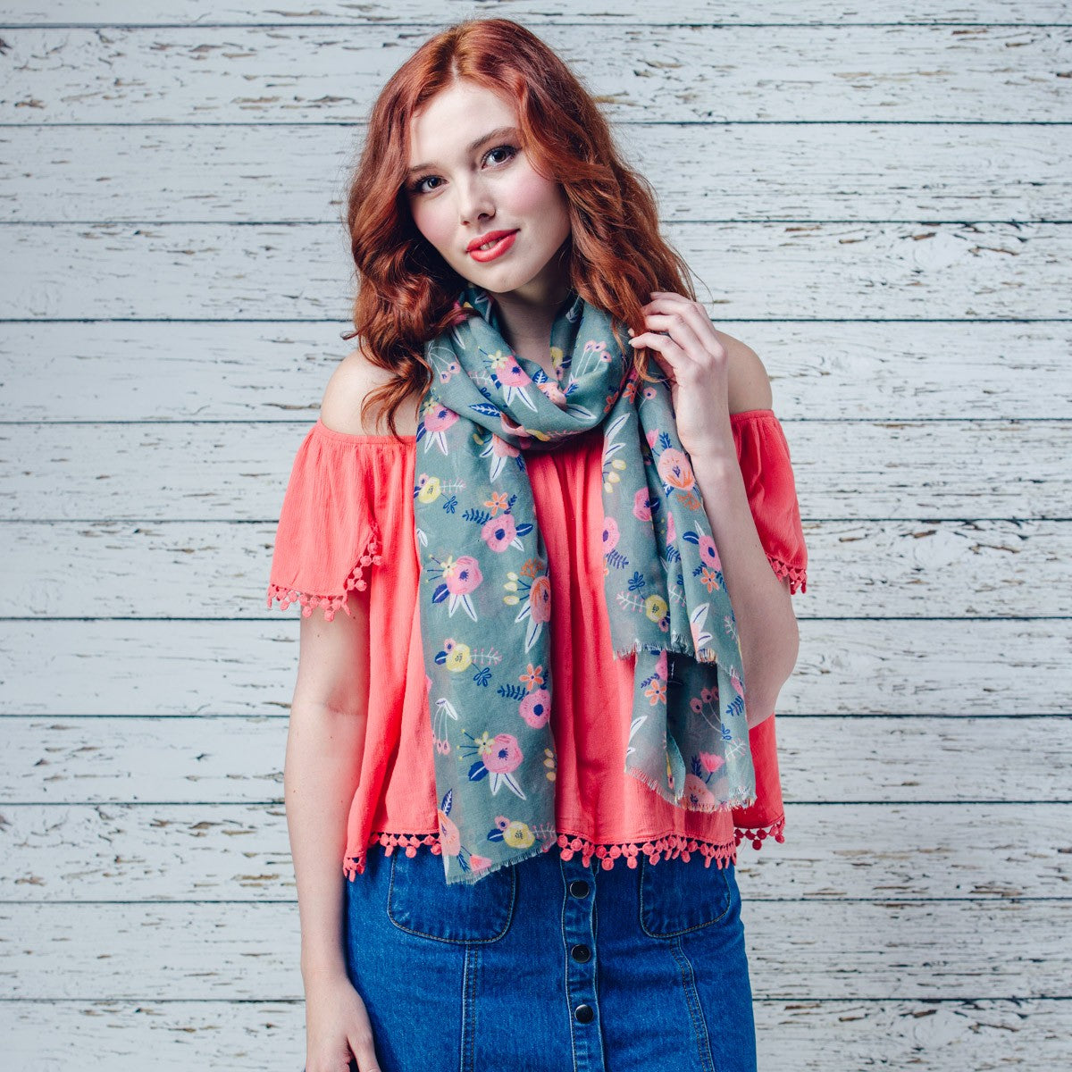 Delicate pastel pink flower printed scarf on a green background with feathered edge