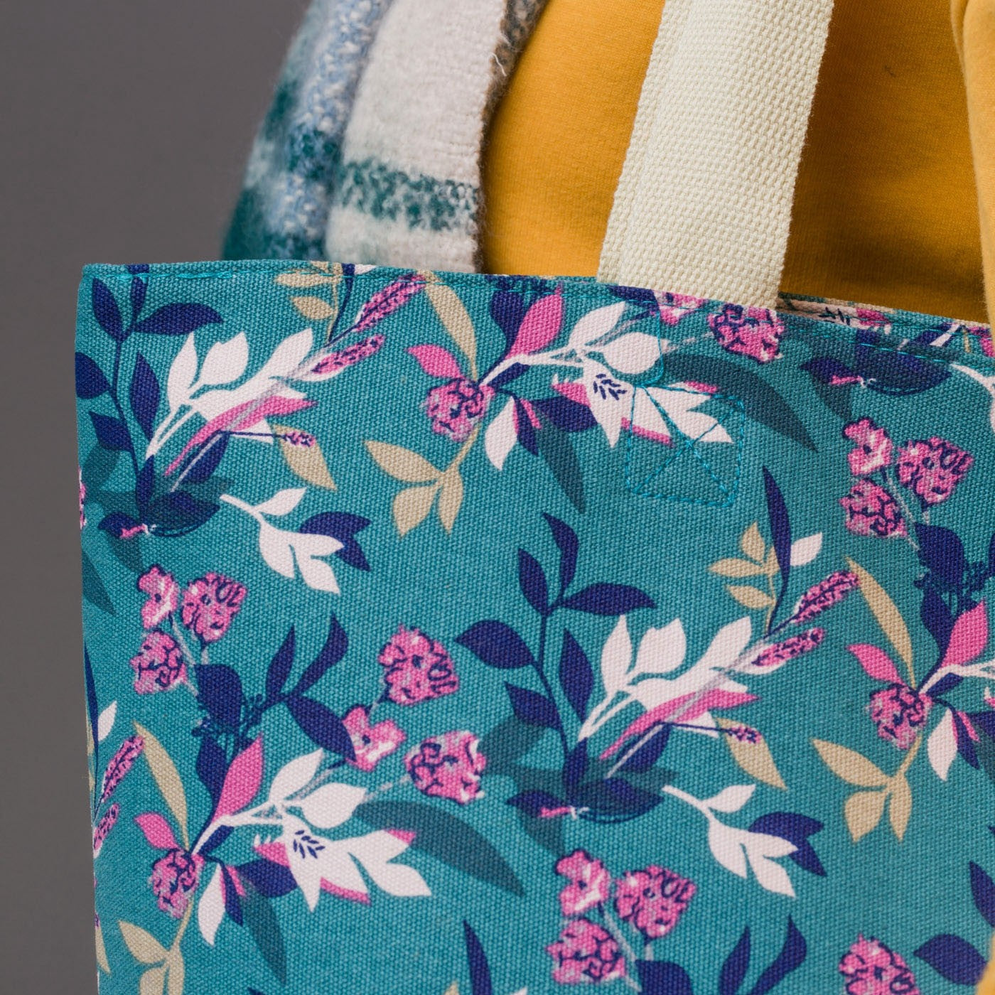 Large canvas bag with vintage style floral print, on a solid green coloured background