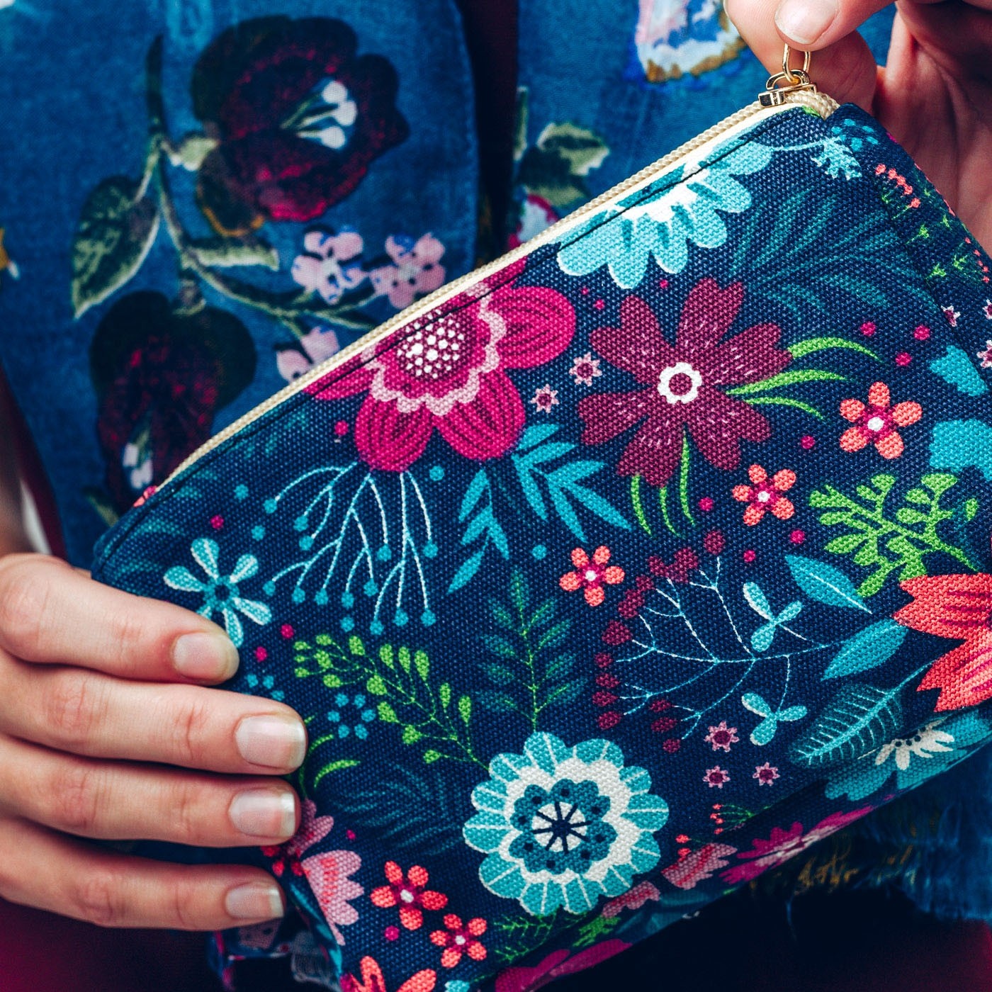 Make up bag in bold blue and pink floral design on a dark background