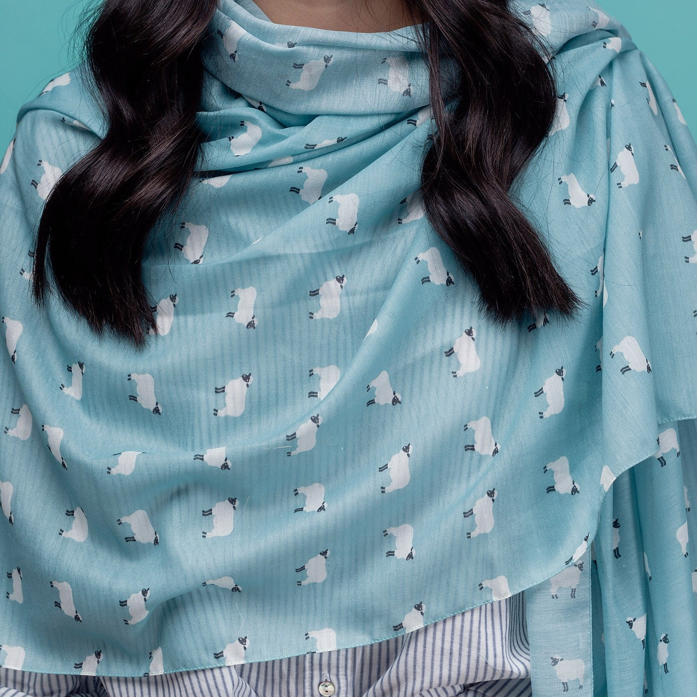 Turquoise sheep print scarf, finished with a rolled edge.