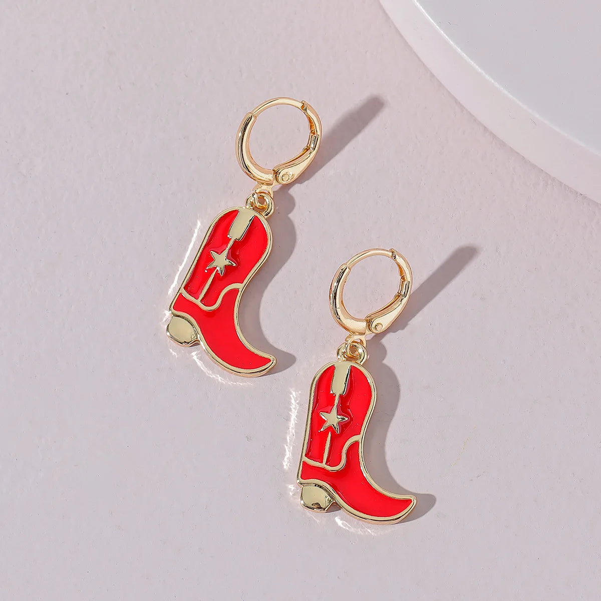 Flatlay of Red Cowboy Boots Gold Hoop Earrings