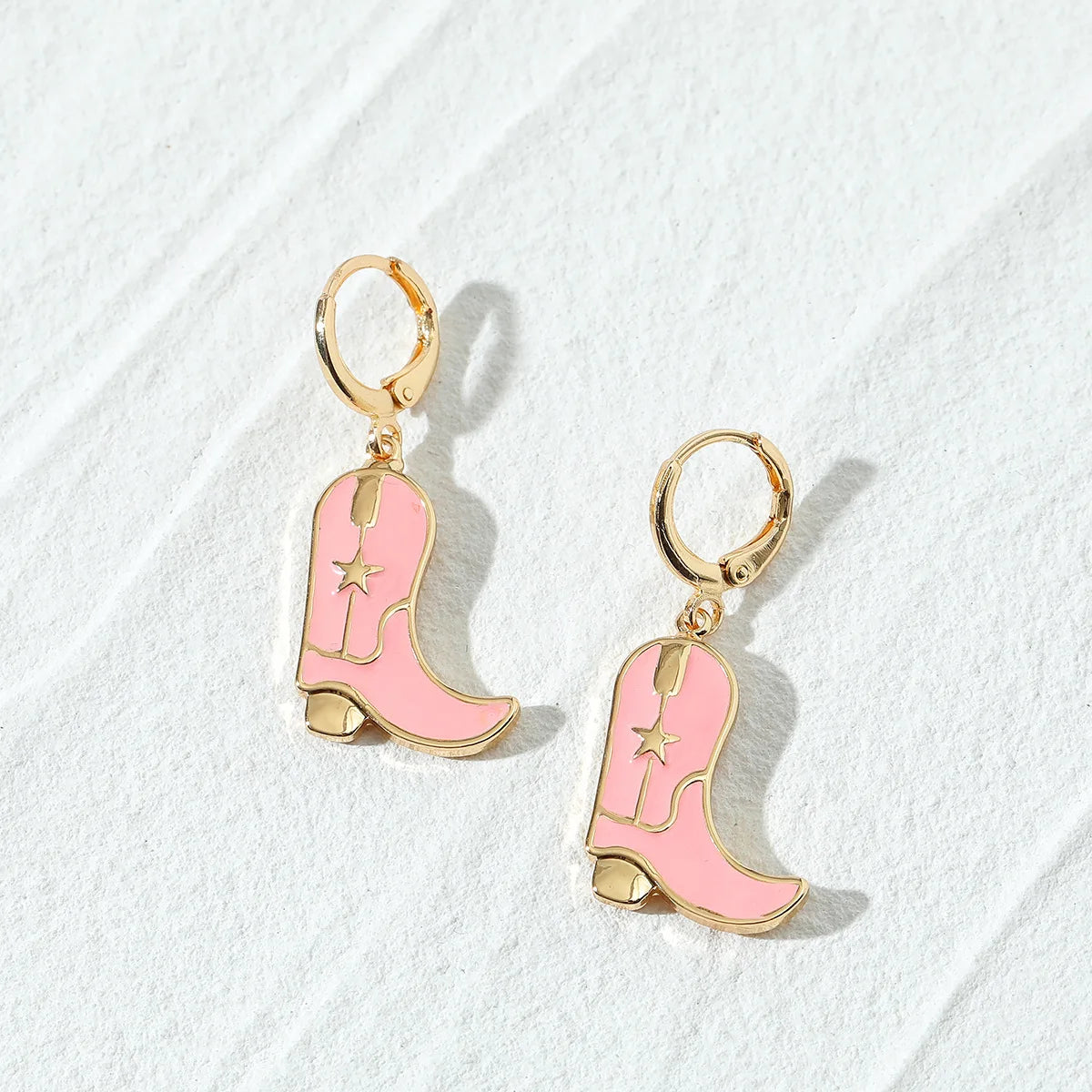 Flatlay of Pink Cowboy Boots Gold Hoop Earrings