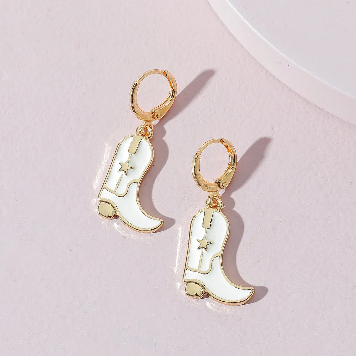 Flatlay of White Cowboy Boots Gold Hoop Earrings