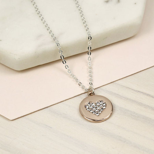 Round disc necklace in a pretty rose gold style finish with a heart inlay dorned with clear faceted crystals