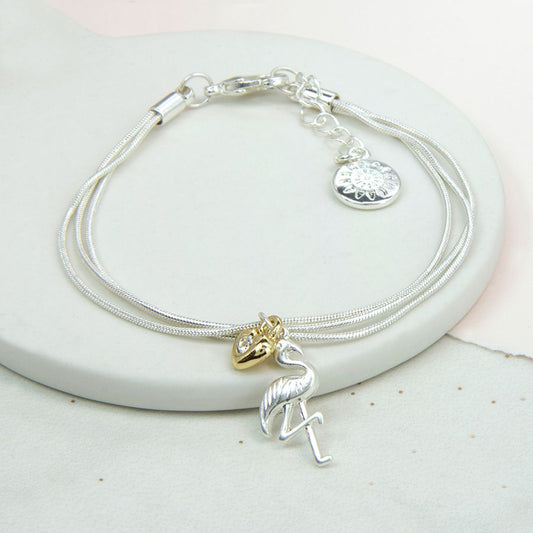 Silver plated triple chain bracelet with a gold silver crystal heart and a silver plated flamingo charm.