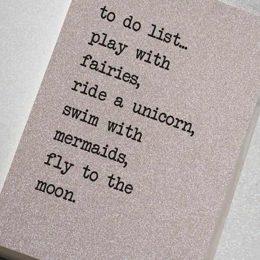 A fabulously sparkling silver glitter effect covered notebook featuring in the slogan: To do list... play with fairies, ride a unicorn, swim with mermaids, fly to the moon.