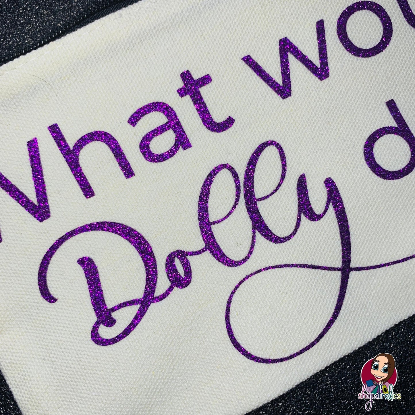 Close up of What Would Dolly Do make up bag with purple glitter lettering 