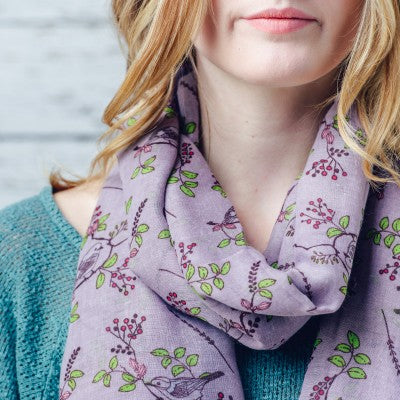 A beautiful bird print design scarf on a solid coloured background and finished with a feathered edge