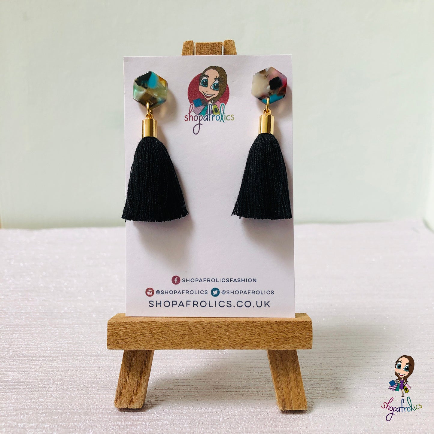 black cotton tassel drop earrings are finished with a vibrant coloured hexagon acrylic ear stud. 