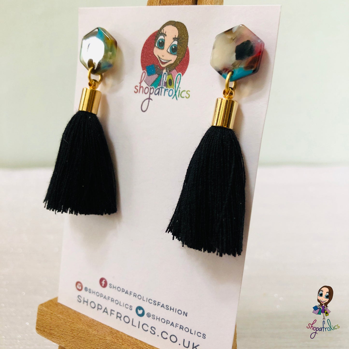 black cotton tassel drop earrings are finished with a vibrant coloured hexagon acrylic ear stud. 