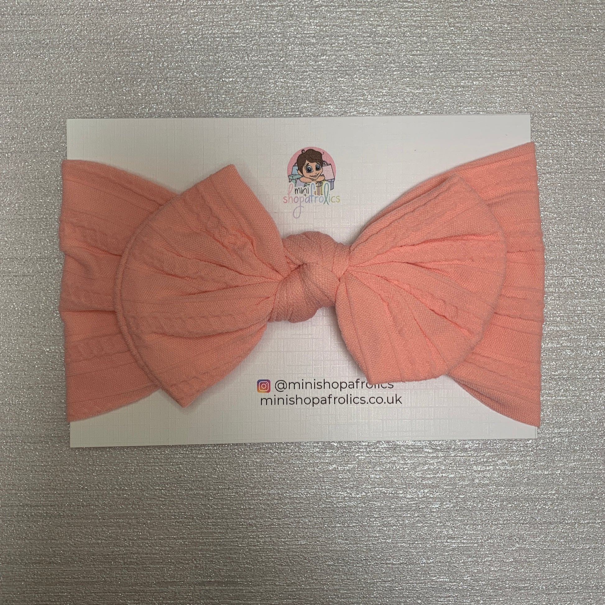 Pink baby bow headband on backing card