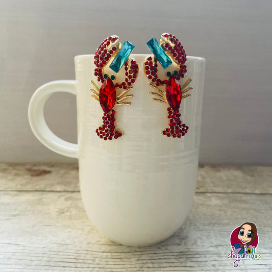 Red lobster earring with blue crystals between pincers