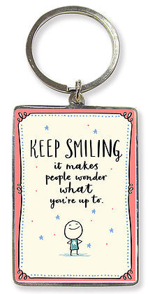 Metal keyring featuring the words Keep Smiling, it makes people wonder what you're up to