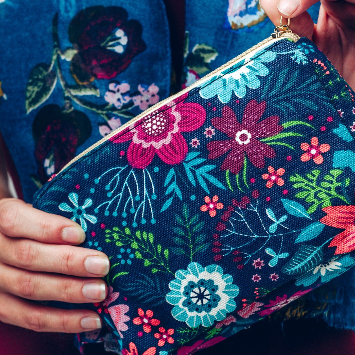 Make up bag in bold blue and pink floral design on a dark background